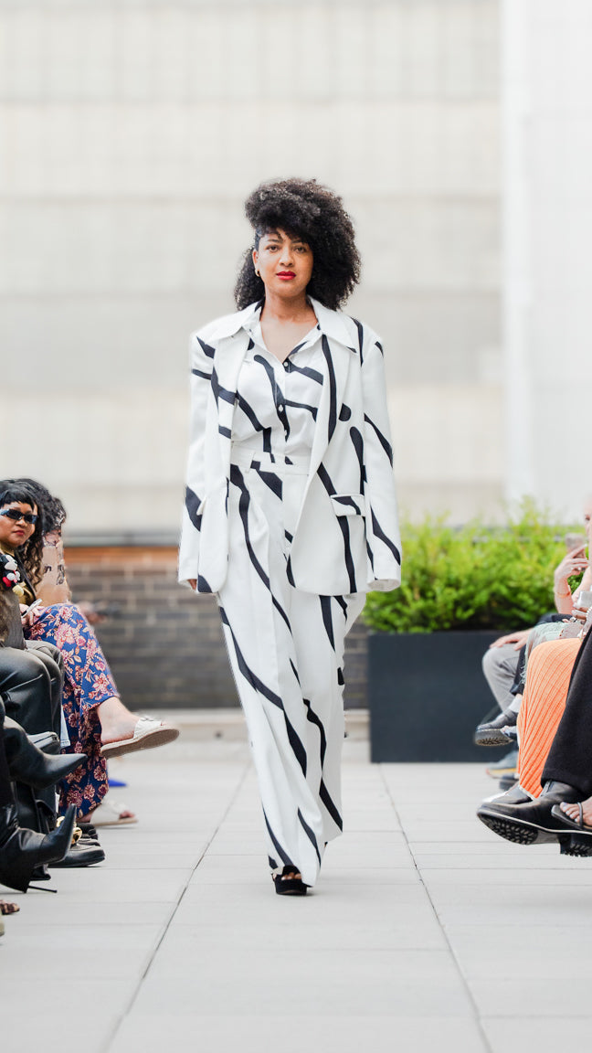 Joyce Granger in a black and white abstract-patterned outfit walking Megan Renee's SS26 fashion show.