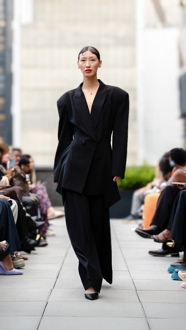Kristine Wang wearing a black suit walking Megan Renee's SS26 fashion show runway.