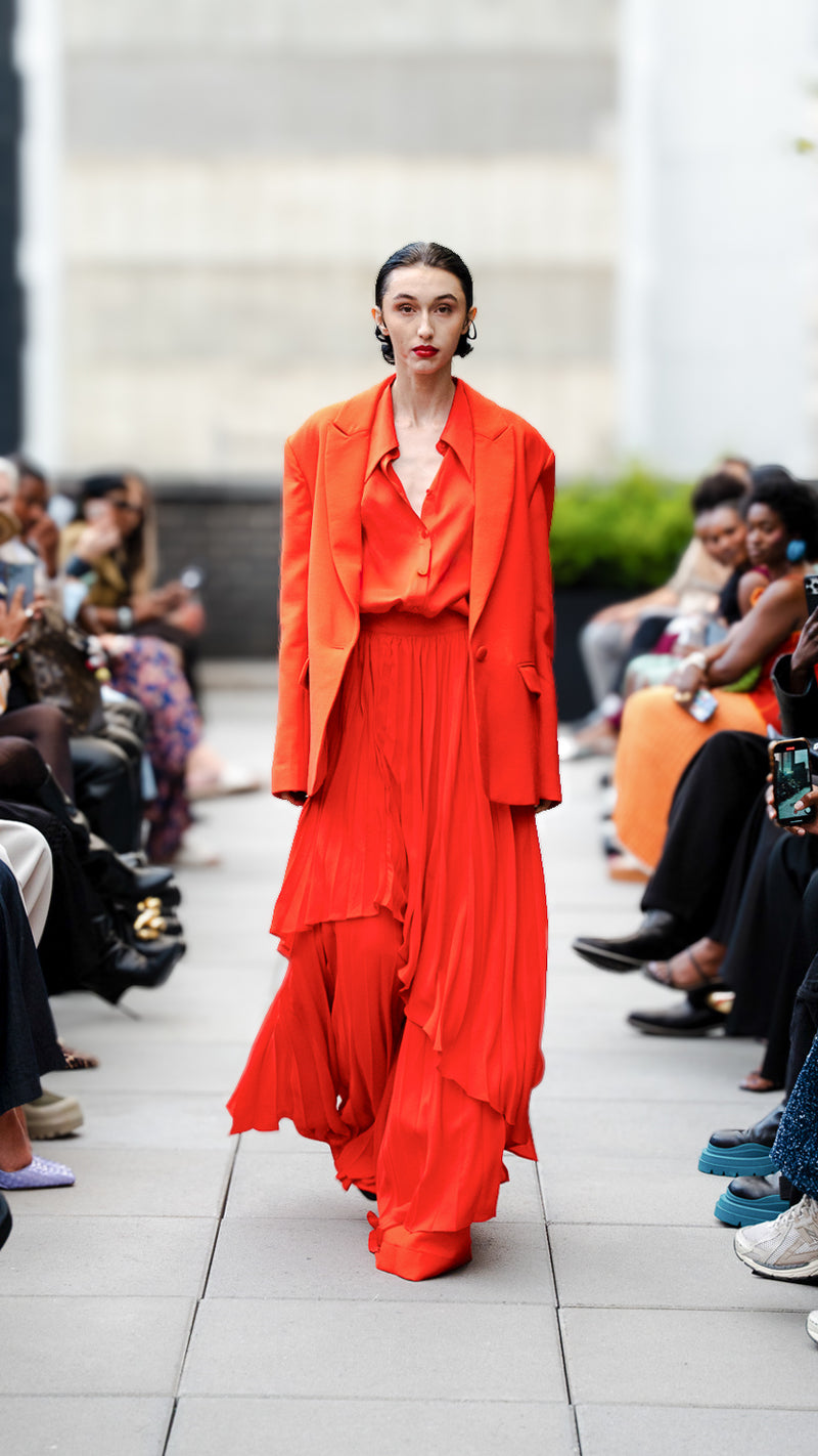 River Rose wearing a bright red outfit on Megan Renee's SS26 fashion show runway.