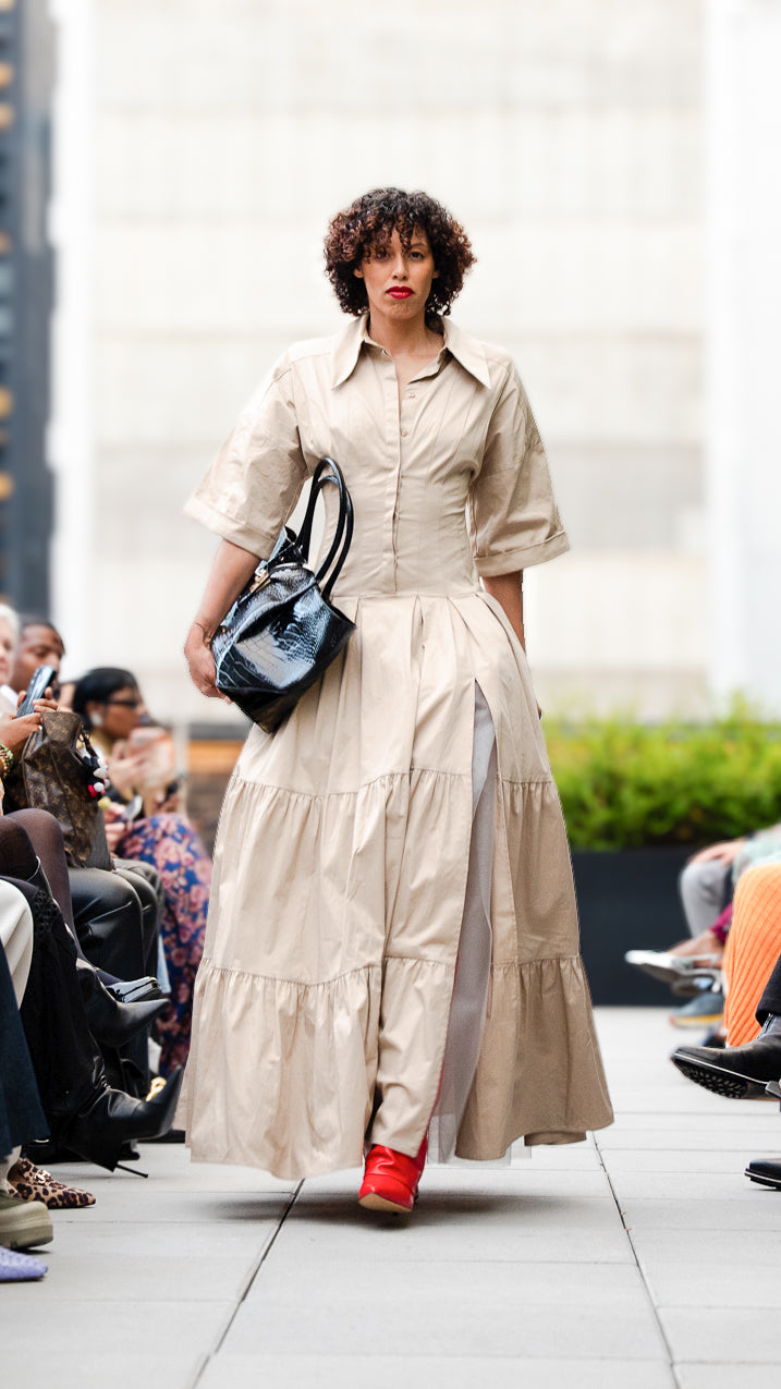 Isabella Machuca wearing a beige dress with a black Mutayo Ekiye bag on Megan Renee's SS26 fashion show runway.